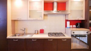 A kitchen with a sink, stove, and cabinets. - GuestHost - The Gardens (Vimodrone)