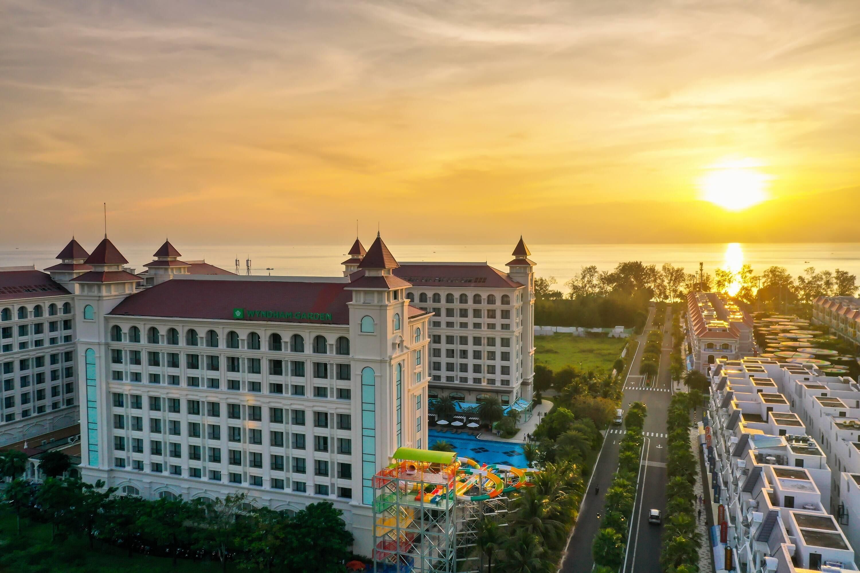A large hotel with multiple towers and a swimming pool.