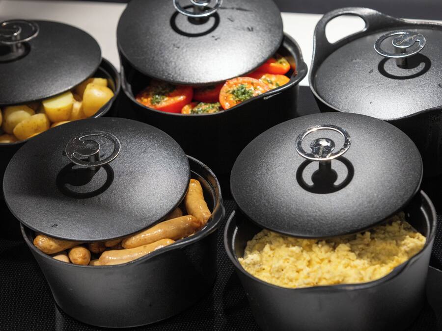 A set of black containers with lids, each containing different food items.