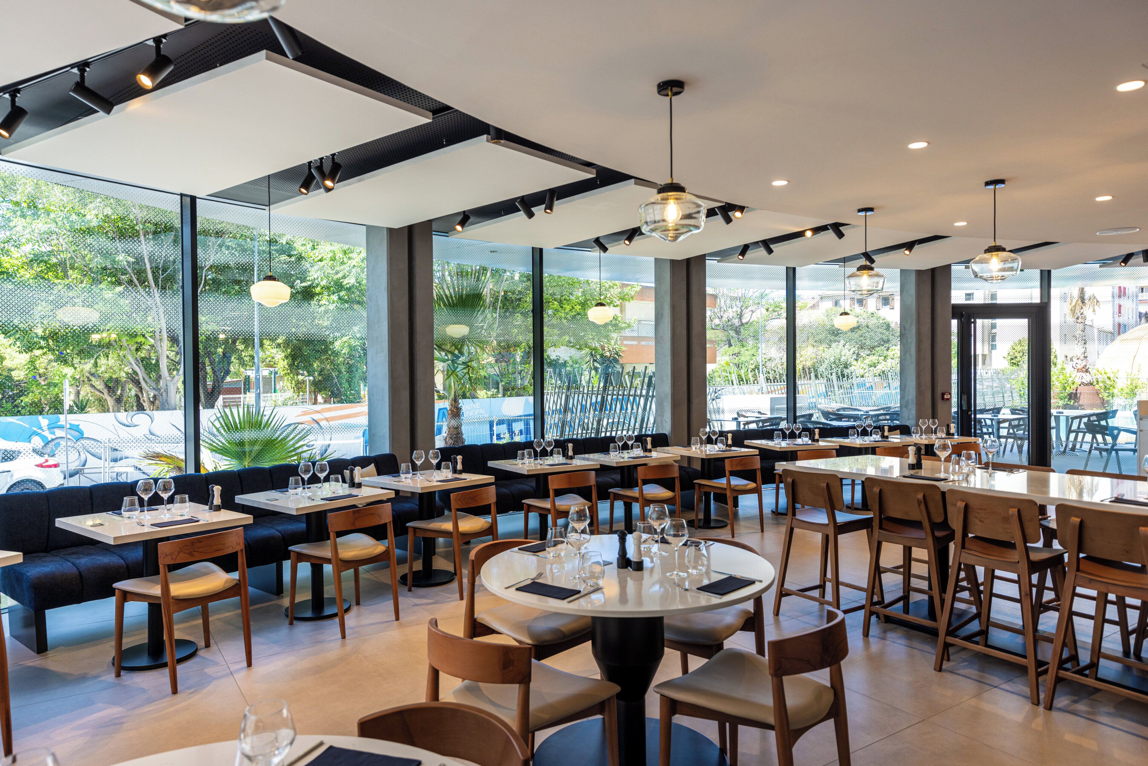 A restaurant with multiple seating areas, including booths and tables, with a view of the outdoors.