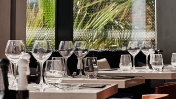 Un ambiente de restaurante con mesas dispuestas para comer, con cristalería y cubertería elegantes.