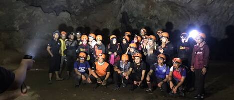 Un grupo de personas con cascos y equipo de seguridad posando para una foto dentro de una cueva.