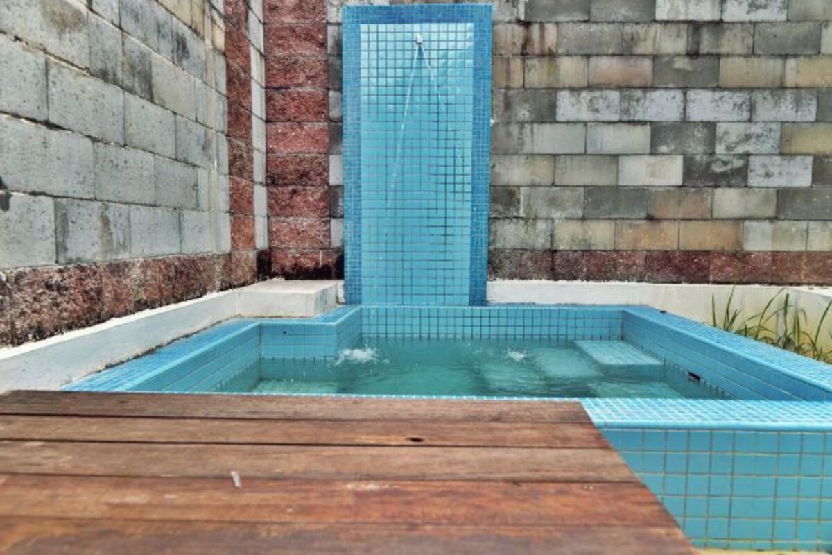 A swimming pool with blue tiled steps and a wooden deck in front.