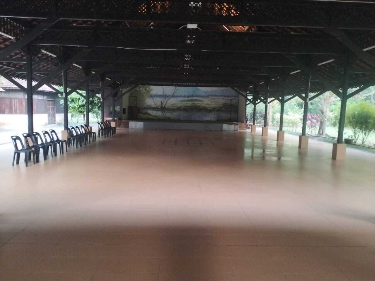 An indoor space with a tiled floor, a central open area, and a view of a landscape through a large window.