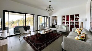 A modern living room with a sofa, coffee table, and bookshelf.