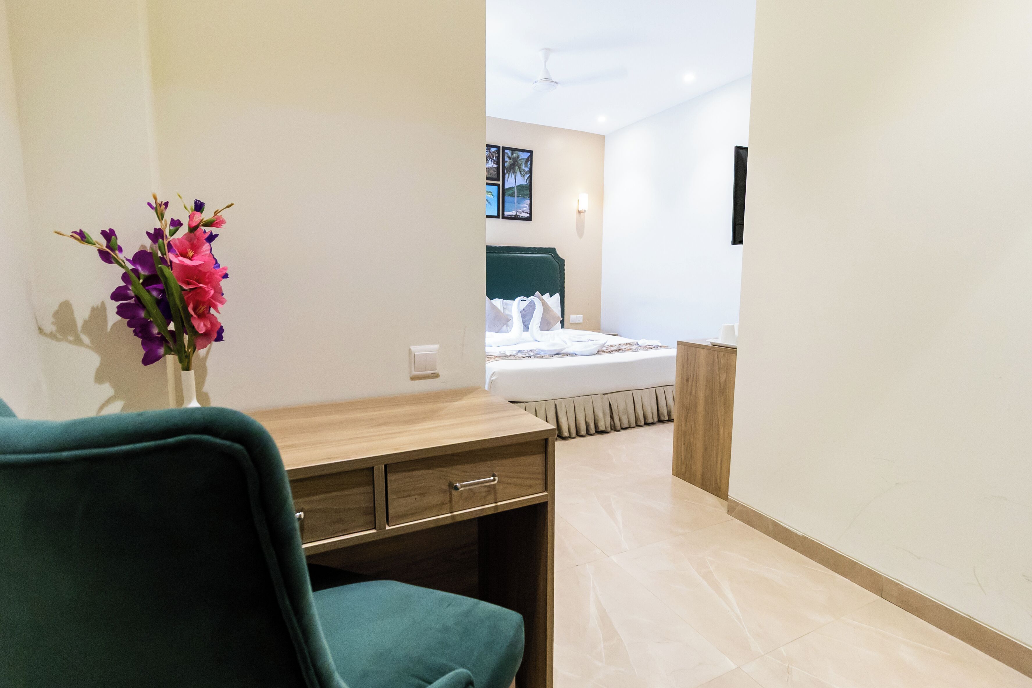 Una habitación de hotel con escritorio, silla y cama con cabecera.