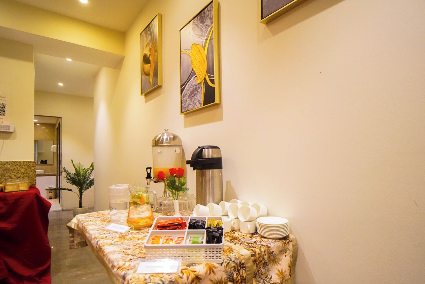 Montaje de bufé con estación de café, dispensador de agua y diversas opciones de comida.