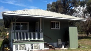 A small, single-story house with a porch, a small attached garage, and a well-maintained lawn.