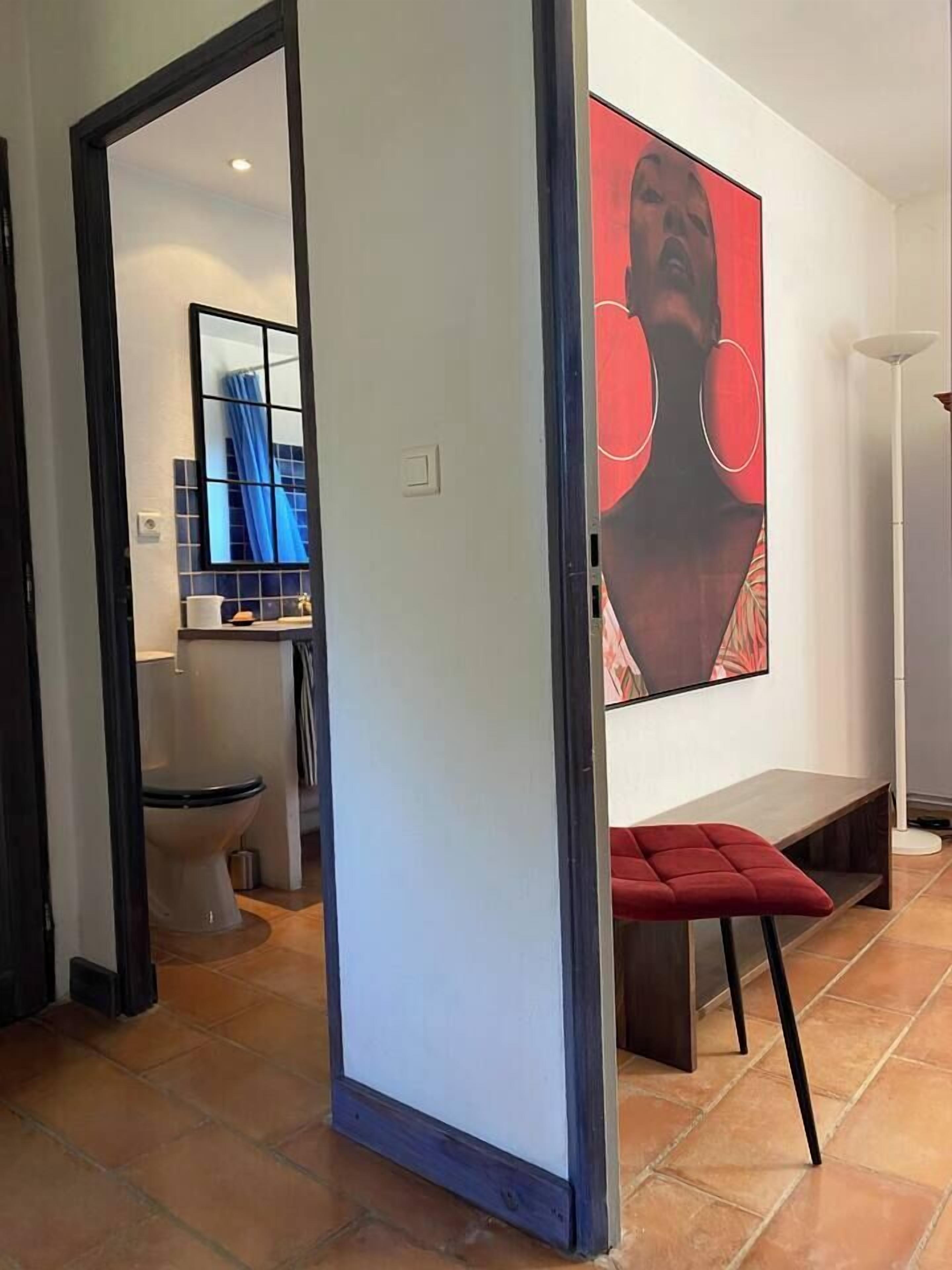 A modern bathroom with a toilet, sink, and mirror.