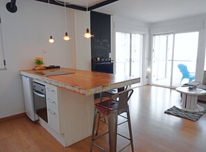 A modern kitchen with a wooden island, bar stools, and pendant lighting. - Garza Playa - Altea, Costa Blanca (Altea)