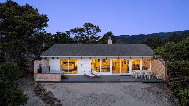Una casa moderna con una terraza amplia, un dormitorio con puerta corredera y un comedor.