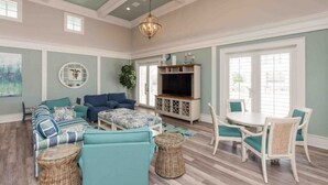 A spacious living room with a large sofa set, a TV, and a dining area with chairs. - SouthernVilla Ticket to Paradise (Palm Coast)