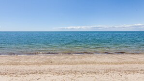 Una playa con vista despejada al mar y una orilla arenosa.