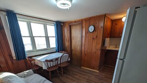 Une petite chambre comprenant un lit, une petite table et un coin cuisine.