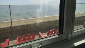 A window with a view of a beach and a clear sky.