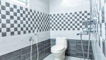 Un baño moderno con inodoro, ducha y salpicadero de azulejos a cuadros.