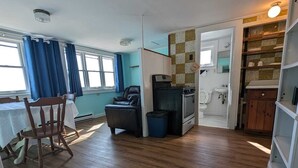 Un espacio habitable compacto con comedor, kitchenette y baño.