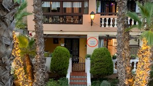 A two-story building with a balcony, a sign with 'BL10 BAJ04', and a well-maintained garden with palm trees and lights. - Comfortable spacious family house with large terrace and garden Beach & Bars (Torrevieja)