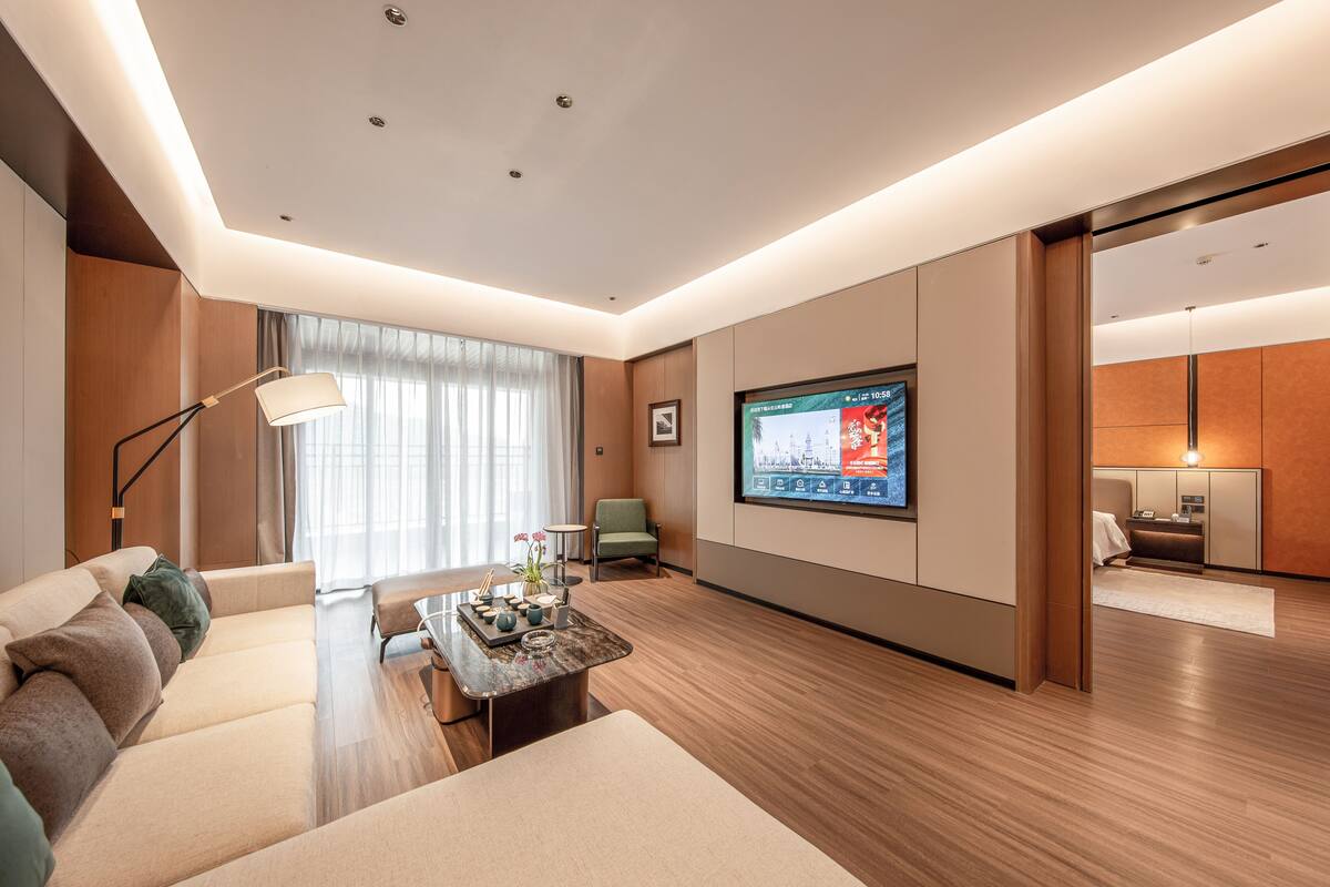 A modern living room with a sofa, coffee table, and a TV mounted on the wall.