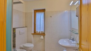 Ein kleines Badezimmer mit Toilette, Bidet und Waschbecken.