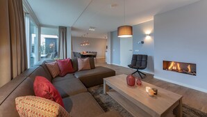 Ein modernes Wohnzimmer mit einer Eckcouch, einem Couchtisch und einem Kamin.