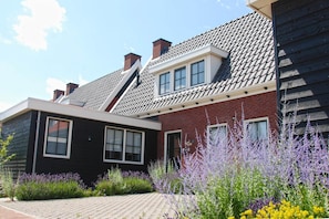 Stunning garden surrounds this modern home with a gabled roof and attached structure.