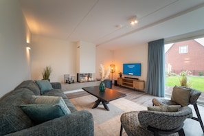 Relax in this stylish living room with a large coffee table, sectional sofa, and armchairs.