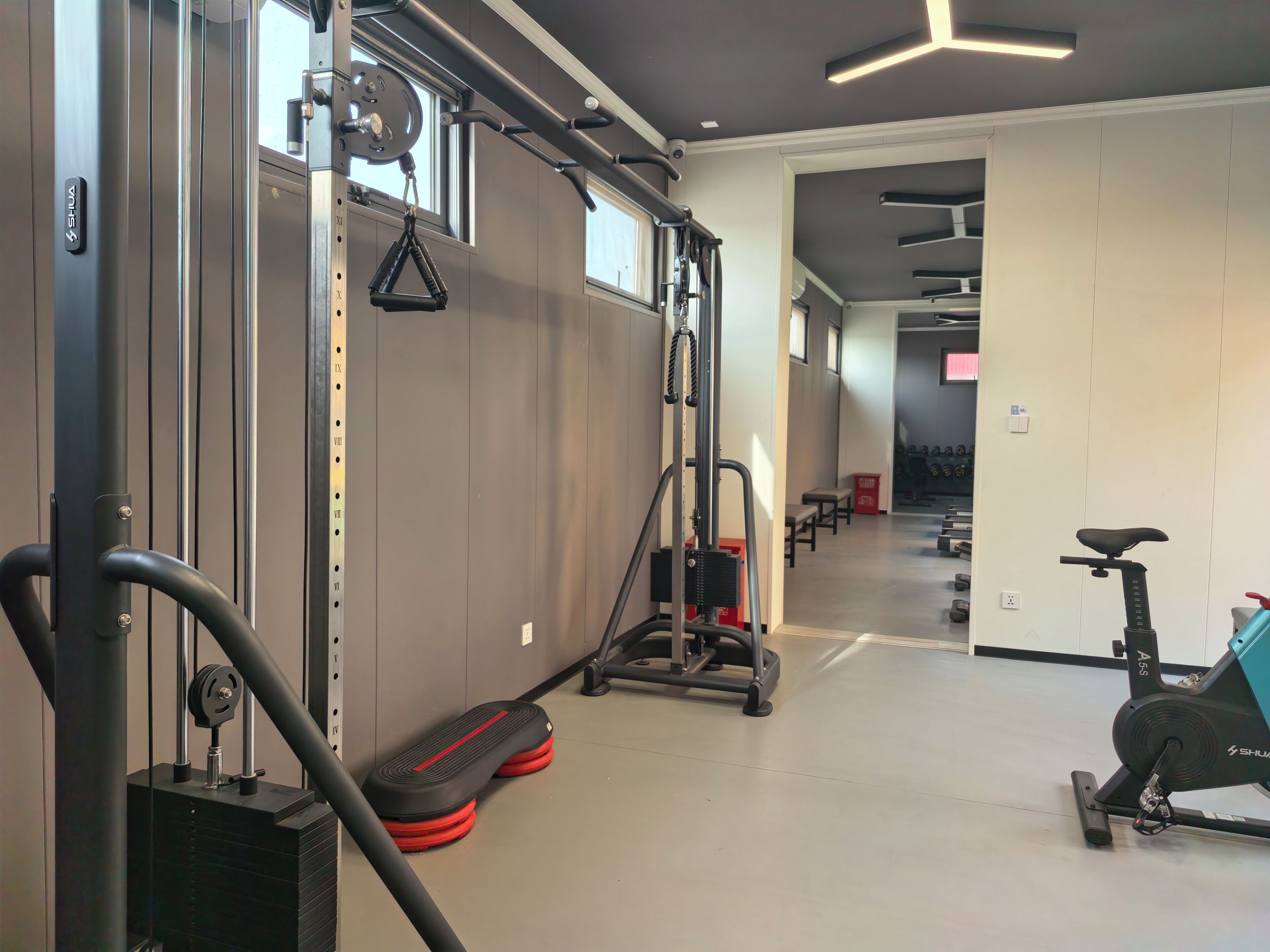 A gym with exercise equipment, including a treadmill, a stationary bike, and weightlifting machines.