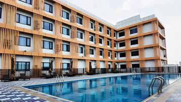 Una piscina al aire libre, sombrillas, tumbonas