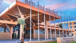 Um edifício moderno com uma entrada ampla e aberta e uma placa com a inscrição 'RED SEA WORLD'.