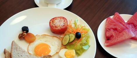 A breakfast plate with toast, a fried egg, a boiled egg, a tomato, cucumber slices, and a salad.