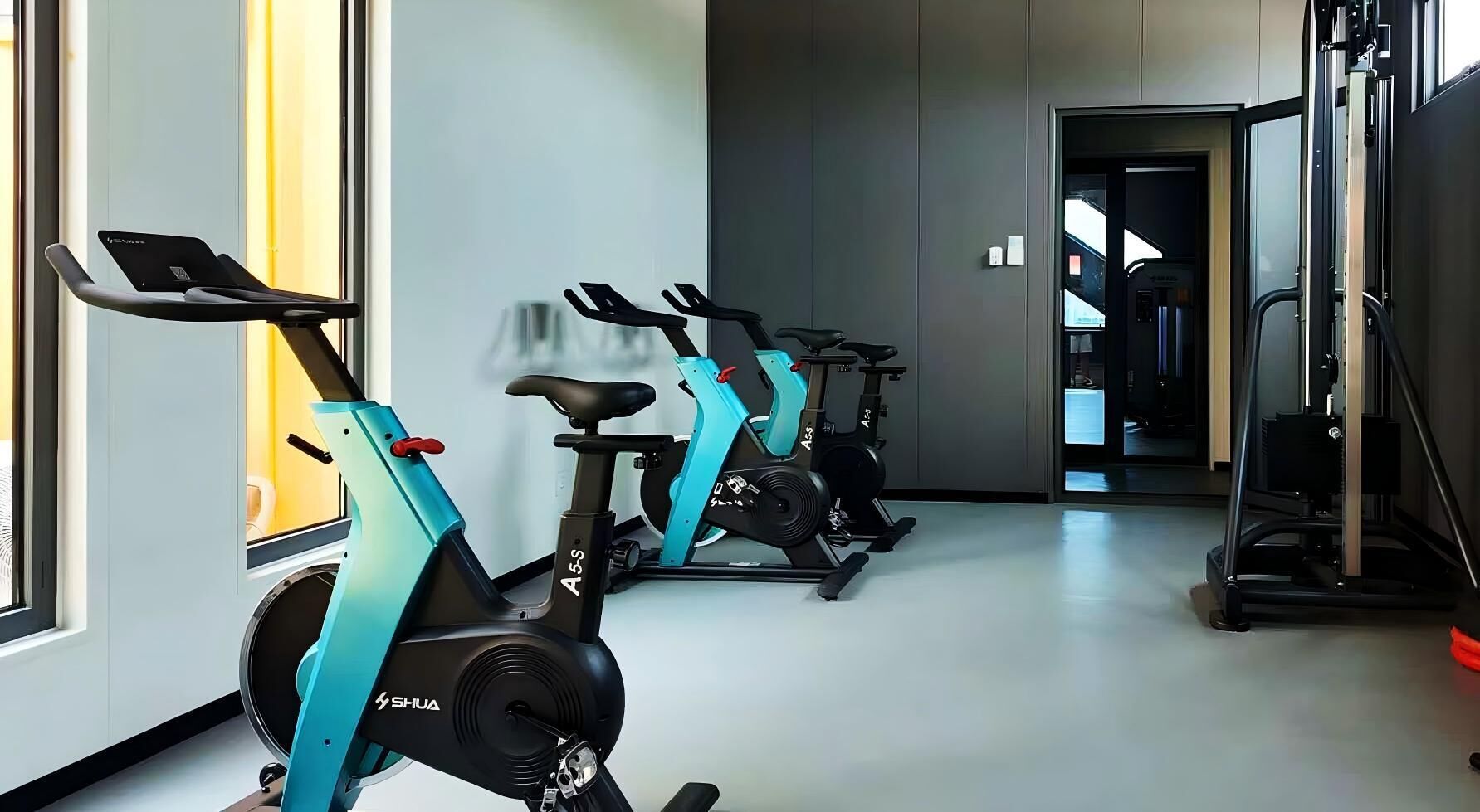 Un gimnasio con bicicletas estáticas y una cinta de correr.