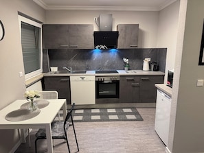 Cozinha compacta com lava-louças, forno e micro-ondas.