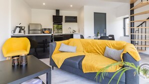 Ein zeitgemäßer Wohnbereich mit Sofa, Esstisch und Küchenzeile.