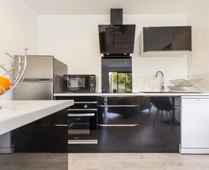 Een moderne keuken met een inbouwoven, magnetron en vaatwasser.