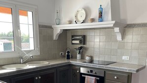Una cucina con forno a incasso, lavello e finestra.