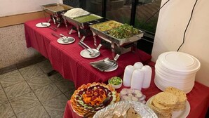 Una mesa de buffet con diversos alimentos y utensilios.