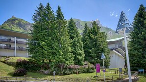 Ein Hotel mit Blick auf die Berge, einem Parkplatz und einem Fußweg.