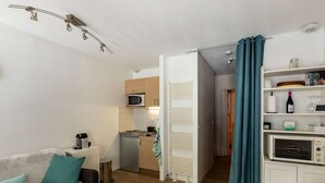 Ein kompakter Wohnbereich mit Küchenzeile, Essbereich und einer Couch.