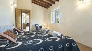A bedroom with a bed, a chair, a lamp, and a window with bars. - Villa Armonia by Interhome (Jávea)