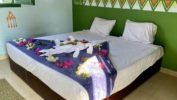 A neatly made bed with a blue and white patterned bedspread, white pillows, and a decorative headboard with a geometric design.