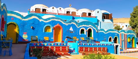 A colorful building with multiple levels, arched doorways, and a variety of seating areas.