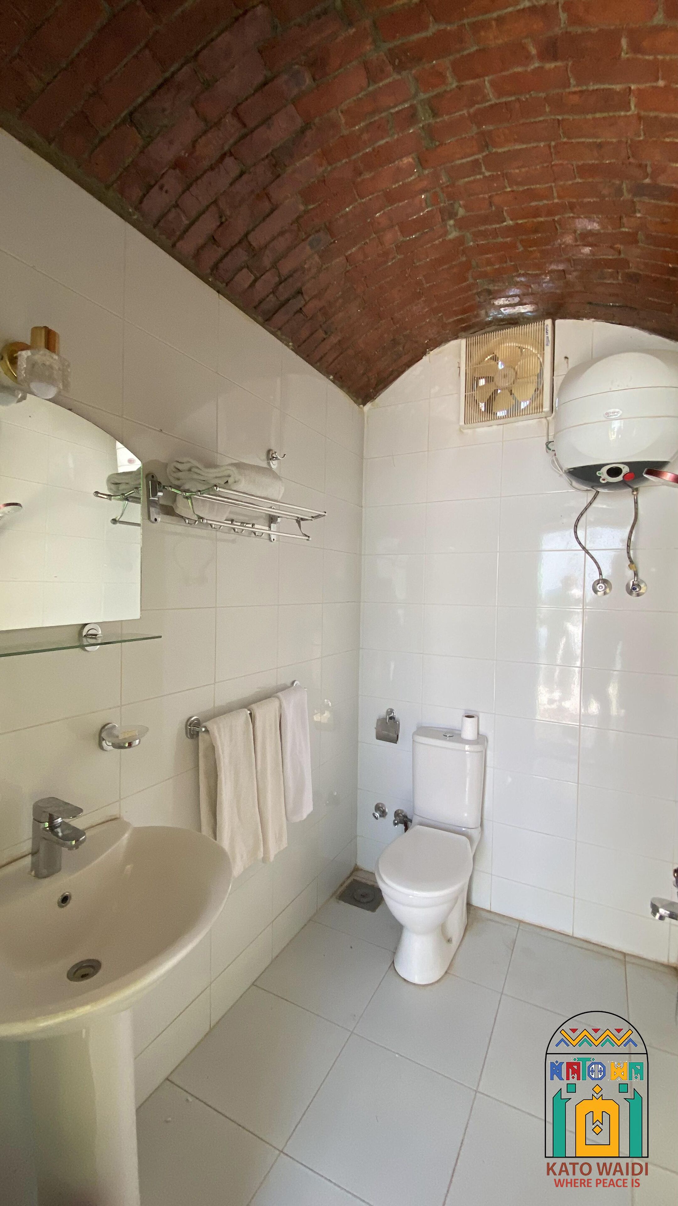 Une salle de bain comprenant un lavabo, des toilettes et un espace douche.