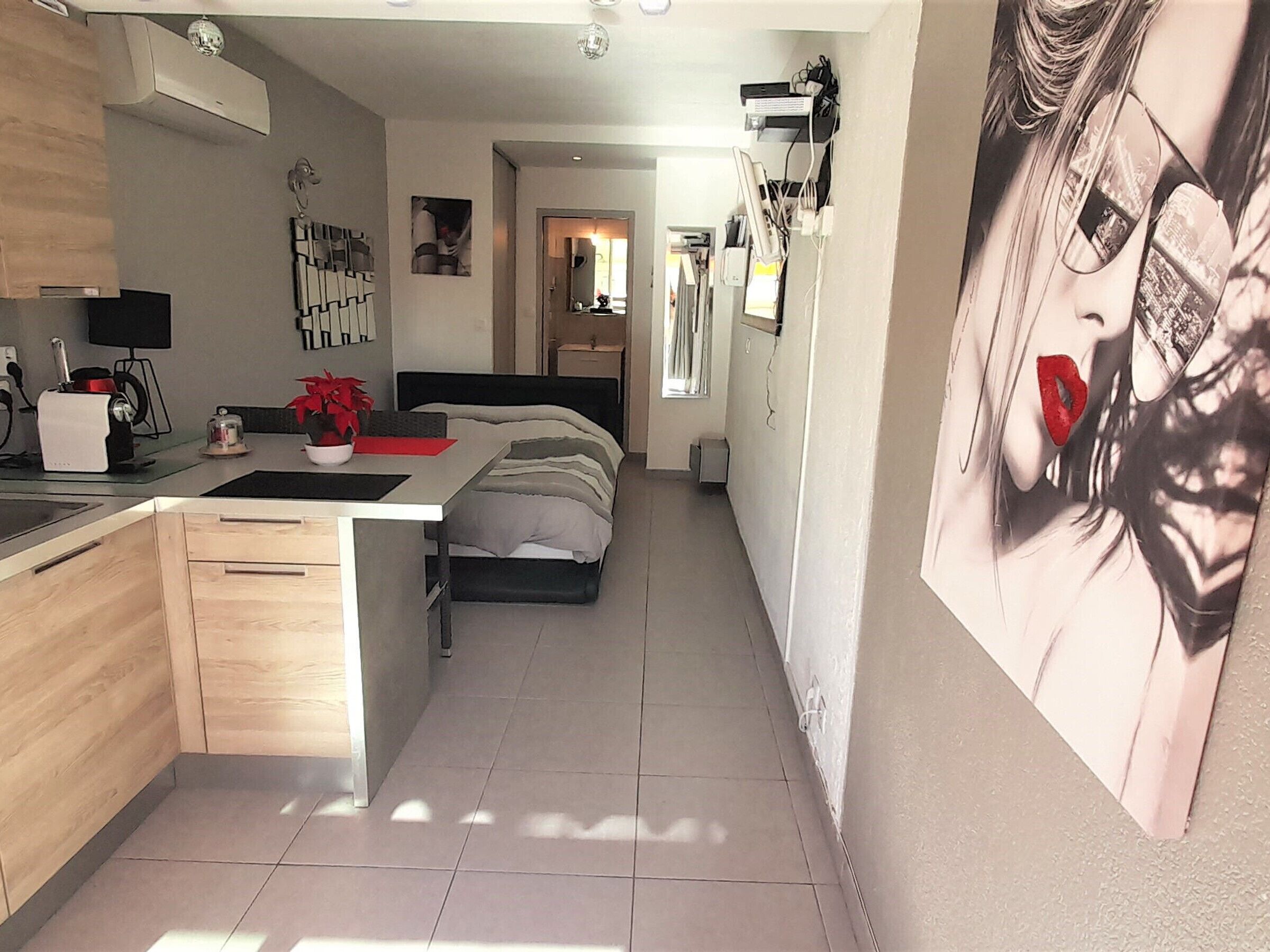 Una cucina moderna con zona pranzo, un letto e un grande poster appeso al muro.
