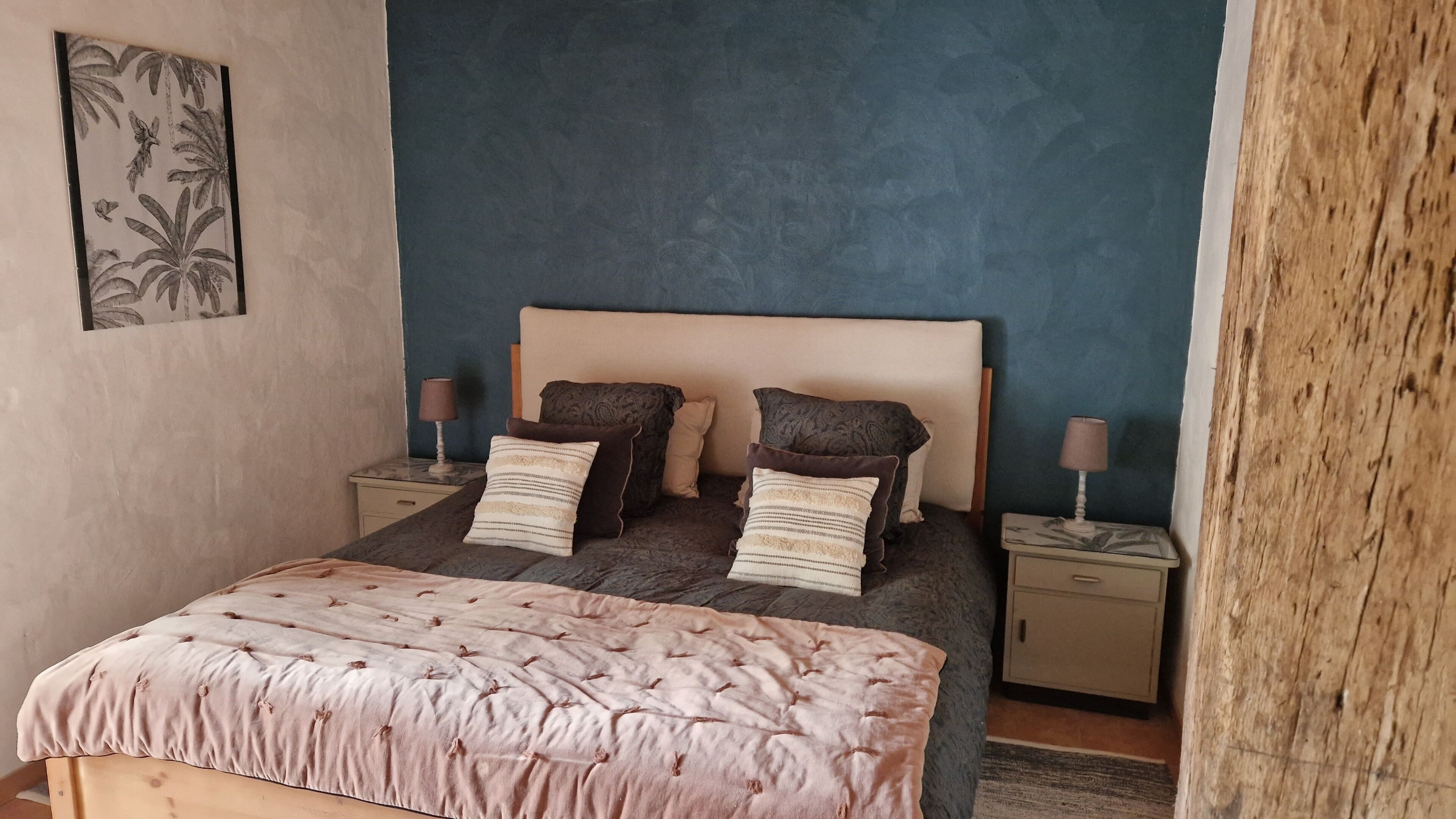 Een slaapkamer met een bed, twee nachtkastjes en een hoofdbord.