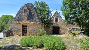 A stone house with a steeply pitched roof, a small window, and a door. - La Bergerie, oasis of calm for visiting the LOT and the Dordogne (Montgesty)