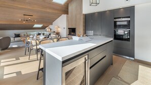 Una cocina moderna con una isla grande, electrodomésticos integrados y un tragaluz.