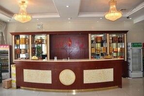 A reception area with a counter, shelves with items, and a chandelier.