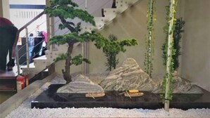 A staircase with a decorative rock garden and bonsai trees. - Shui Jie Hostel (Xing'an County)
