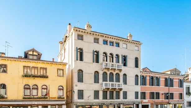 A row of historic buildings with arched windows and balconies, featuring a variety of architectural styles. - GuestHost - The Venice Red Door Aparment (Venezia)